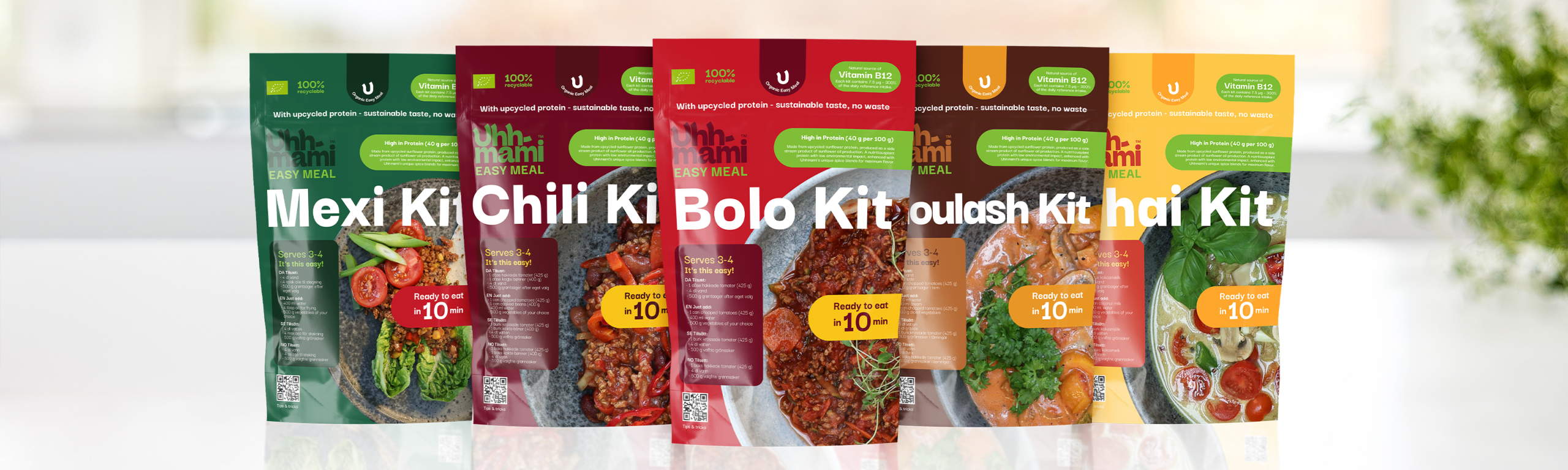 Fem farverige "Uhhmami" økologiske madpakker er linet op med Mexi, Chili, Bolo, Goulash og Thai kits. Hver pakke fremhæver bæredygtighed.